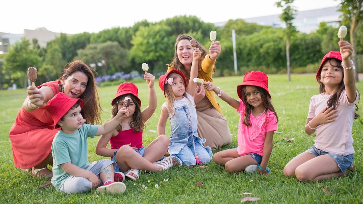 A joyful family enjoying ice cream on a sunny day in a Portuguese park.